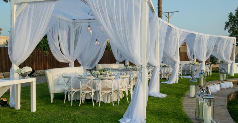 Draped dining area for seaside wedding