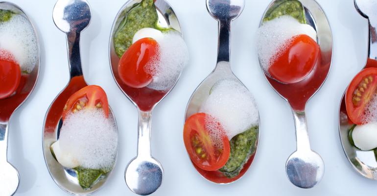 From Epicurean Caprese spoons with fresh mozzarella pear tomatoes nutfree basil pesto and white balsamic foam Photo by Laurie Smith