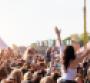 Woman at music festival with arms in air
